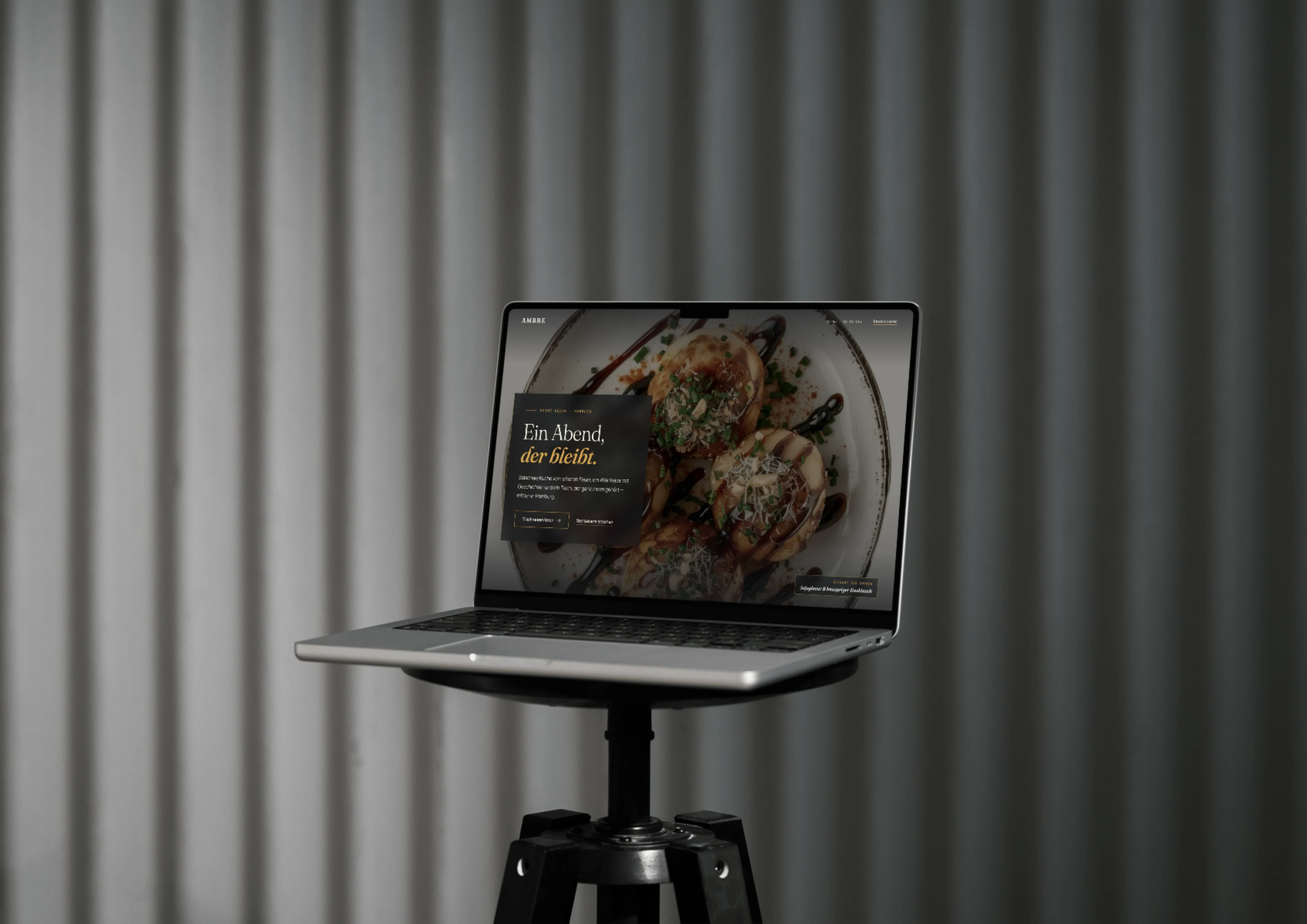 MacBook mit einer fertigen Website-Präsentation auf einem Stativ